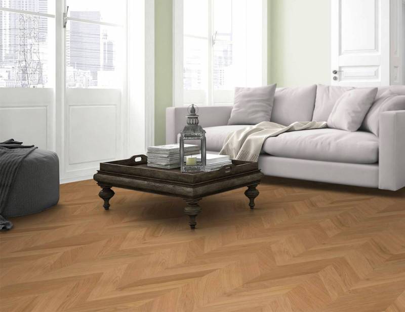 Salon moderne avec canapé blanc et parquet en bois clair posé en chevron, créant une ambiance lumineuse.