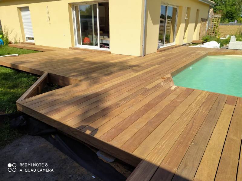 Terrasse en bois clair neuve autour d'une piscine rectangulaire et d'une maison jaune. REDMI NOTE 8 AI QUAD CAMERA.