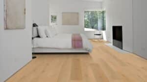 Design moderne : chambre lumineuse, lit blanc, plancher en chêne clair. Cheminée intégrée et fenêtre panoramique sur la nature.